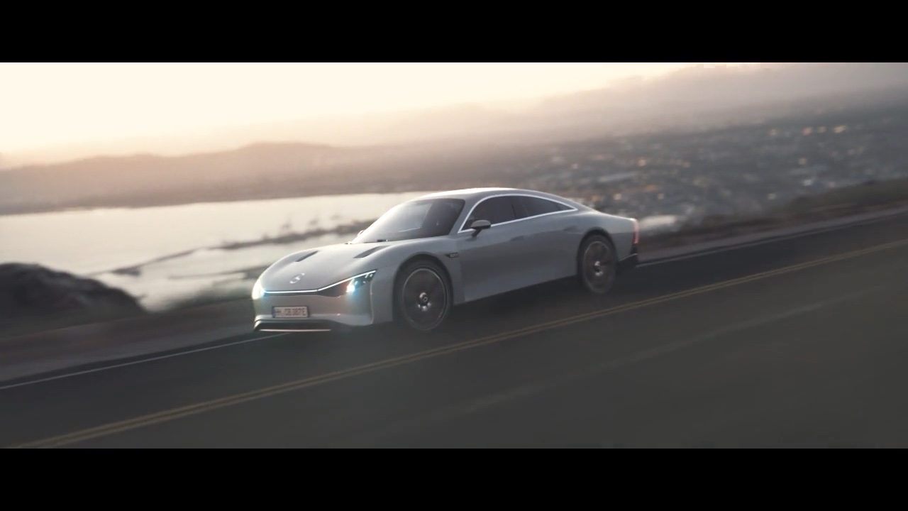 Silberner Mercedes-Benz VISION EQXX fährt auf einer Bergstraße, im Hintergrund Küste und weite Landschaft